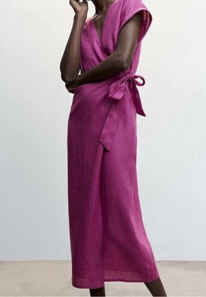 Person wearing a sleeveless, knee-length magenta wrap dress with side tie bow, standing against a plain light background.