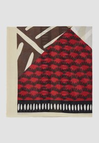 Écharpe multicolore avec des motifs abstraits en rouge, noir et crème. Présente une bordure à franges et un design géométrique avec des détails contrastés.