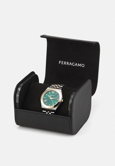 Ferragamo watch in a black leather case. Features a teal dial, gold accents, Roman numerals, and a black-and-silver bracelet design.
