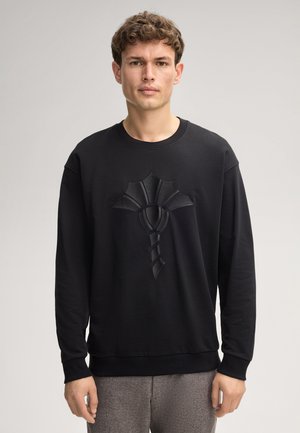 Schwarzes Sweatshirt mit langen Ärmeln, das ein strukturiertes, geprägtes Design auf der Vorderseite aufweist. Rippkragen und -bündchen mit lockerer Passform.