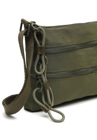 Maslinasto zelena najlonska torba s tri zatvorena džepa, ojačanim šavovima, podesivim tekstilnim remenom i dekorativnim trakama.