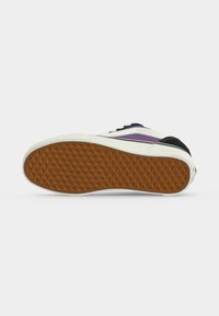 Σόλα ενός low-top αθλητικού παπουτσιού με καφέ υφή βερίκοκου, λευκή ενδιάμεση σόλα και μωβ-μαύρο επάνω μέρος με λευκή λωρίδα.