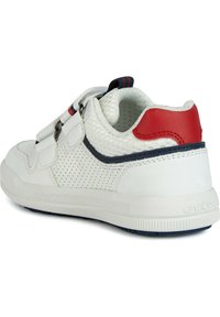 Sneaker bianca con pannelli in rete, dettagli rossi e navy, doppi cinturini a strappo, punta arrotondata e suola in gomma bianca testurizzata.