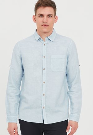 Light blue long-sleeve shirt made of a textured fabric. Features a button-down front, chest pocket, and brown buttons on the placket.