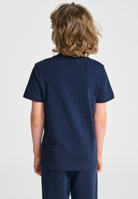 Granatowa bawełniana koszulka z okrągłym dekoltem i krótkimi rękawami, o gładkiej fakturze i standardowym kroju, zaprezentowana z tyłu.