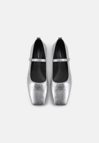 Silver metallic ballet flats with a square toe design. Features a single strap and smooth texture, set against a black insole.