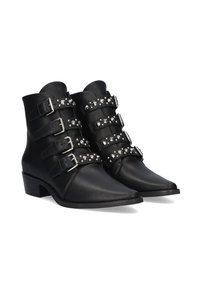Botines de cuero negro con cuatro hebillas plateadas y tachuelas decorativas en las correas. Punta afilada y tacón bajo en bloque.