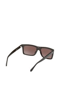 Czarne plastikowe okulary przeciwsłoneczne z brązowymi, przyciemnianymi soczewkami. Kwadratowe oprawki mają teksturowane boki i metalowe akcenty. Lekka konstrukcja.