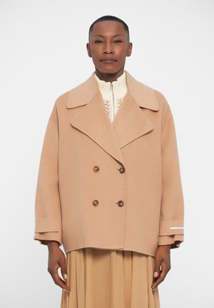 Double-breasted beige wool coat with large lapels, two brown buttons, and white accent stripes on sleeves. Relaxed fit with patch pockets.