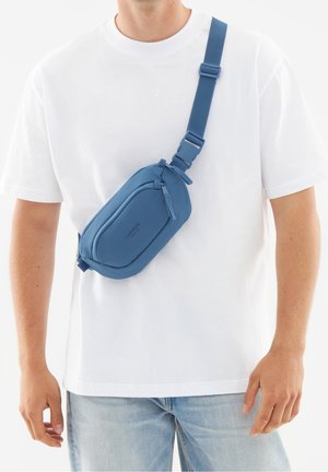 Riñonera azul hecha de material texturizado, con cierre de cremallera, correa ajustable y un diseño elegante y redondeado. Sin marcas visibles.