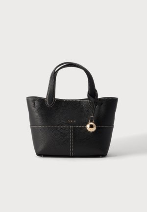 Black textured leather handbag with short handles, white stitching, small gold brand logo, and a round gold charm hanging from one handle.