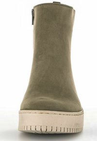 Stivale alla caviglia in suede verde oliva con punta rotonda e cerniera laterale, dotato di suola spessa beige e battistrada testurizzato per una buona aderenza.