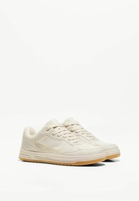 Beżowe sneakersy z gładkiej skóry, o okrągłym nosku, sznurowanym zapięciu i gumowej podeszwie z subtelnym wzorem bieżnika.