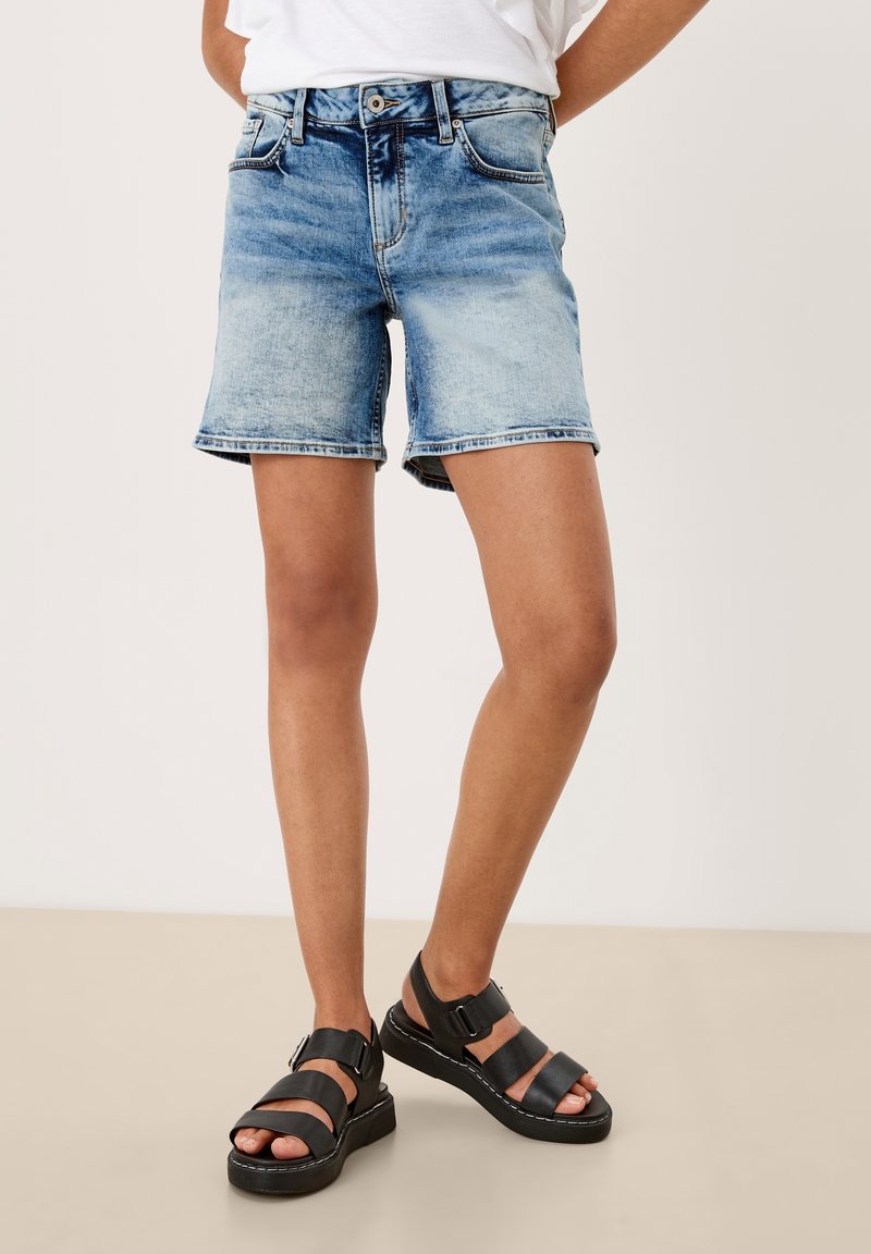 Džínové šortky v světle modré barvě s vybledlým omakem, s mírně zvýšeným pasem, pěti kapsami a viditelným prošitím.