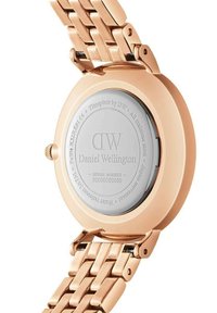 Rose gold metal watch with a round case, mesh bracelet design, and engraved silver back featuring the brand name and serial number.