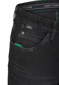 Schwarze Jeans mit subtiler Textur, ausgestattet mit einem grünen Mobiltelefon-Beutel-Label, Kontrastnähten und einem Bund, der mit "Club of Comfort" gebrandet ist.