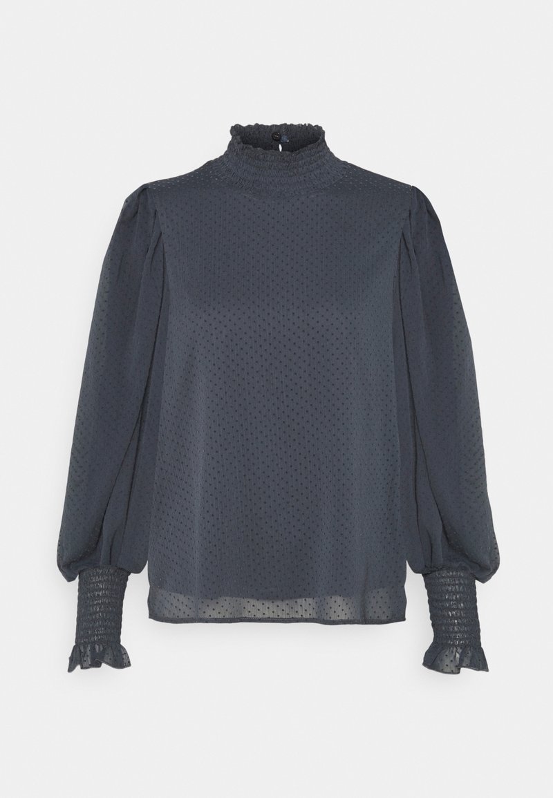 Blouse noire transparente à petits pois, avec col montant froncé et poignets, manches longues bouffantes, et fermeture par boutons au dos.