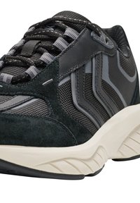 Athletischer Schuh mit einem Obermaterial aus schwarzem Wildleder und Mesh, tonal grauen Akzenten, einer gepolsterten, cremefarbenen Zwischensohle und einer strukturierten, schwarzen Gummisohle.