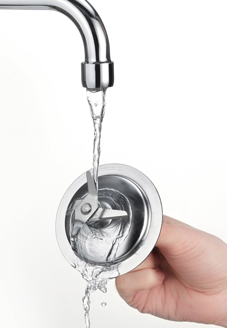 Edelstahl-Spülenabdeckungen mit drei scharfen Klingen, Wasser fließt hindurch, von einer Hand gehalten. Glatte, glänzende Oberfläche, kreisförmiges Design.