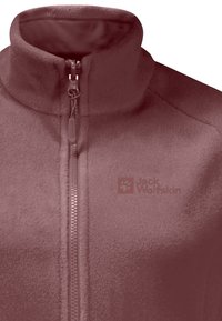 Giacca in pile color mauve con colletto alto. Presenta una cerniera a tutta lunghezza e il logo Jack Wolfskin sul petto. Materiale morbido.