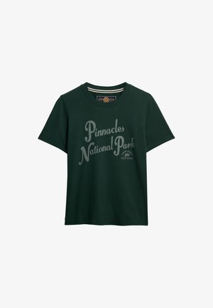 Donkergroene katoenen t-shirt met een ronde hals, met witte tekst "Pinnacles National Park" en het merlogo op de voorkant gedrukt.