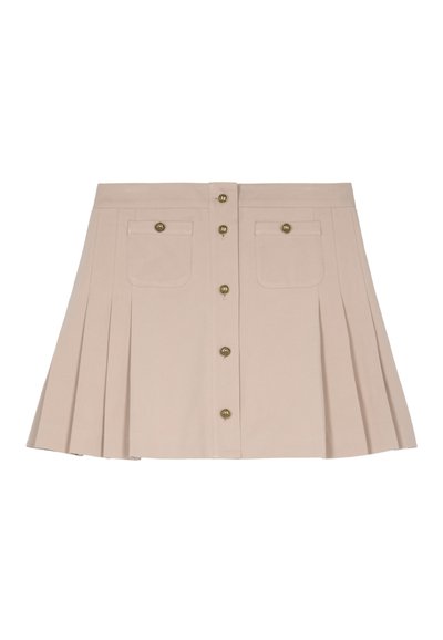 Beige geplooide rok met twee voorzakken, koperen knopen en een aansluitende tailleband. De stof lijkt glad en gestructureerd.