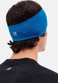 Blauwe sportieve hoofdband gemaakt van rekbare stof, met een gestructureerd ontwerp. Reflecterend logodetail aan de achterkant.