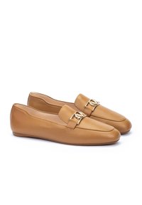 Des mocassins en cuir tan présentent un col rembourré, une boucle métallique décorative à l'avant et une semelle plate simple pour le confort.