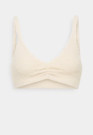 Kremowy dzianinowy biustonosz typu bralette z cienkimi ramiączkami, dekoltem w kształcie litery V i marszczeniem na środku przodu.