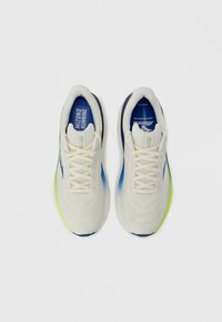 Chaussures de course légères avec une tige crème, des accents bleus et une semelle extérieure vert néon. Présentent une surface texturée et une fermeture à lacets.