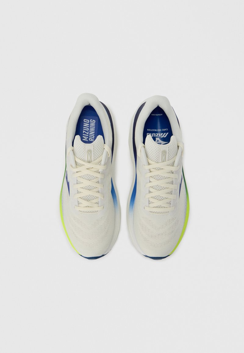 Zapatillas de running ligeras con parte superior en color crema, detalles en azul y suela exterior de neón verde. Presentan una superficie texturizada y cierre de cordones.