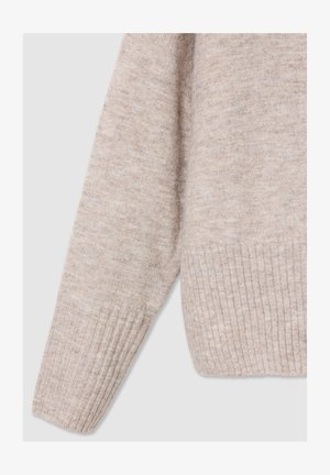 Jasno beżowy sweter z dzianiny, z prążkowanym dołem i mankietami, o miękkiej teksturze i luźnym kroju. Materiał wydaje się lekko melanżowy.