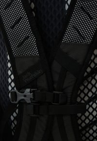 Schwarzes Netzgeschirr mit verstellbaren Riemen, Kunststoffschnallen und einem strukturierten Stoff. Besitzt ein Logo-Tag an einem Riemen zur Identifizierung.