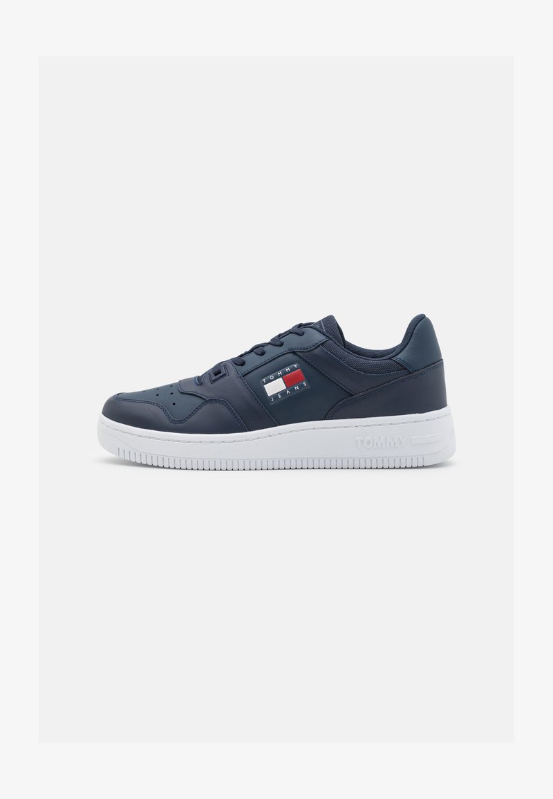 Sneaker da uomo in blu navy con tomaia in morbida pelle sintetica, suola in gomma bianca e dettagli di branding sottili con accenti rossi e bianchi.