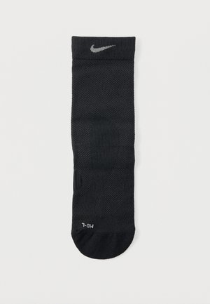 Schwarze Sportsocke mit strukturierter Oberfläche, geripptem Bündchen und silbernem Nike-Logo oben. Verfügt über verstärkte Fersen- und Zehenbereiche.