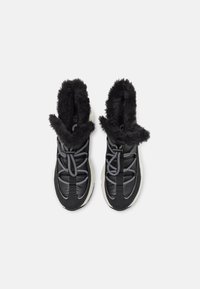 Μαύρα sneakers με φλοίδωτο εσωτερικό, με υφή στην επιφάνεια και παχύ λευκό πέλμα, διακοσμημένα με γκρι κορδόνια και λεπτομέρειες.