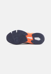 Men's sneaker sole with a textured navy blue rubber outsole, orange accents, and white detailing in a wave pattern for traction and flexibility.