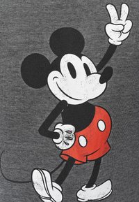 T-shirt grigia con una grafica in stile vintage raffigurante un topo cartone animato in pantaloni rossi, con il segno della pace sollevato, dettagli in bianco e nero.