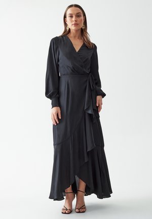 Black wrap dress with long sleeves, flowing skirt, ruffled hemline, and a tie at the waist. Smooth fabric with a matte finish.