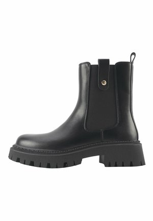 Bottes de cheville en cuir noir avec une semelle en caoutchouc épaisse, des panneaux latéraux élastiques et une languette. Présente une finition lisse et des accents striés.