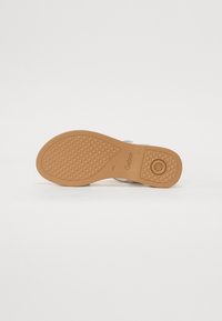 Sandales Gabor avec une semelle en caoutchouc marron texturée présentant des motifs géométriques et des détails de rembourrage, conçues pour le confort et la stabilité.