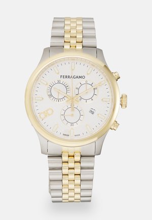 Ezüst és arany krónográf óra fehér textúrázott számlappal, három segédszámlappal, dátumablakkal és rozsdamentes acél karkötővel.