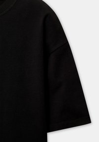 Tricou scurt, negru, cu mânecă scurtă, cu un guler rotund, realizat dintr-un material moale din bumbac și cu o terminare curată, cusută. Design simplu, fără modele sau accente.