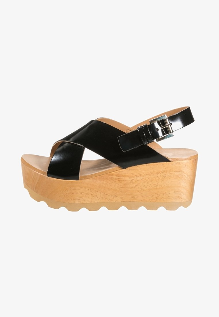 Sandales à talons compensés en cuir verni noir avec une semelle en bois, dotées de brides croisées et d'une fermeture à boucle ajustable. Semelle texturée.