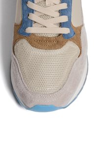 Sneaker con materiali in rete beige e suede; presenta accenti blu e marroni, punta tonda e suola azzurro chiaro. I lacci sono color crema.