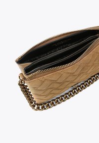 Borsa a tracolla in camoscio beige trapuntato con tracolla in bronzo, dotata di apertura a doppia cerniera e tre scomparti interni.