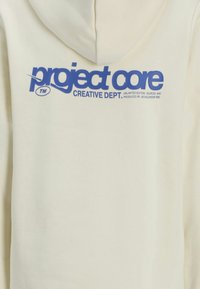 Cremefarbener Hoodie mit großem blauen Aufdruck "project core CREATIVE DEPT." Weicher Stoff mit lockerer Passform und Kapuze.