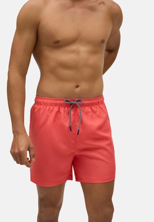 Bañador de coral con una cinturilla que cuenta con un cordón de ajuste acentuado en azul. Fabricado con material ligero, de longitud hasta la rodilla y con una textura suave.