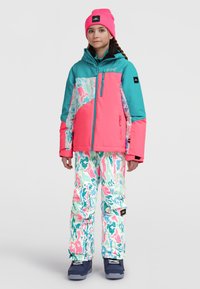 Kleurjack voor sneeuw in teal en roze met een geometrisch ontwerp, gecombineerd met losvallende sneeuwbroek met een patroon in pastelkleuren. Beanie inbegrepen.