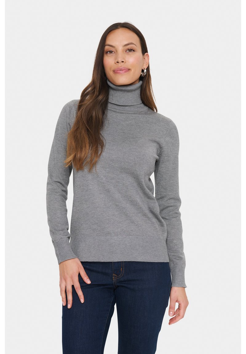 Pulover gri cu guler înalt, confecționat dintr-un tricot moale și ușor, cu mâneci lungi și tiv ondulat, asociat cu blugi negri.